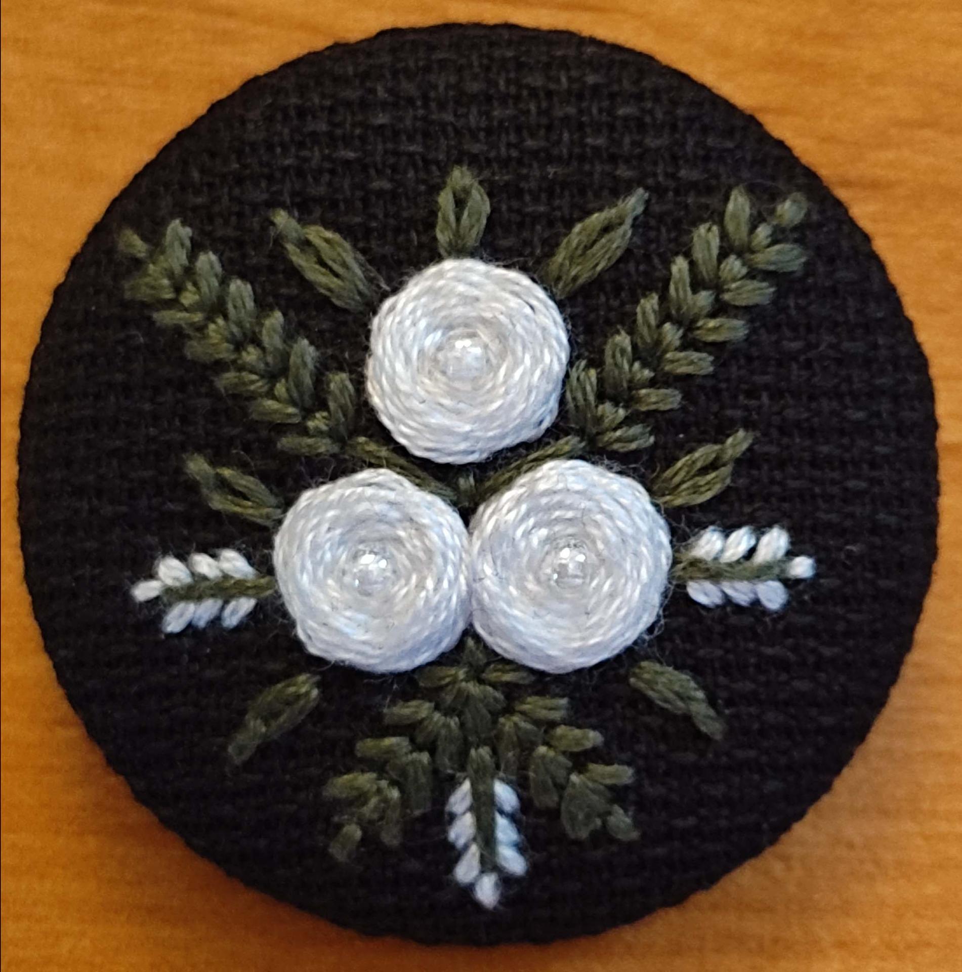7 mini broches fond noir roses blanches